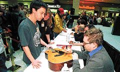 Steven Page signs a guitar for fan Rick Allen. (By Rick MacWilliam)